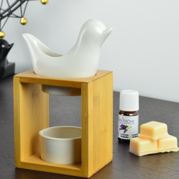 Queimador de aromas de madeira e cerâmica com óleo essencial e barras de cera sobre mesa escura