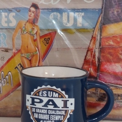Caneca azul escura com texto em português e imagem de mulher de bikini ao fundo