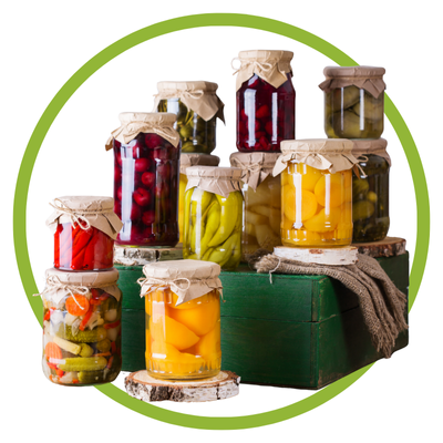 Frascos de vidro com conserva de legumes e frutas variados sobre caixas e troncos de madeira