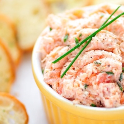 Patê rosa com ervas em recipiente amarelo e pão torrado