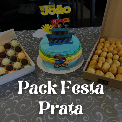 Bolo decorado azul e verde com figuras de papel e caixas de doces e salgados sobre mesa com toalha cinza