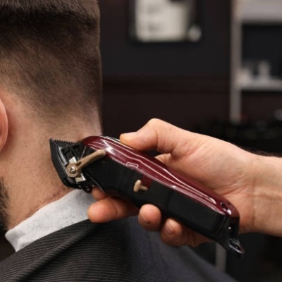Máquina de cortar cabelo a aparar barba de um homem num salão