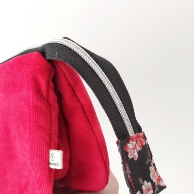 Bolsa vermelha de veludo com alça preta e detalhe floral
