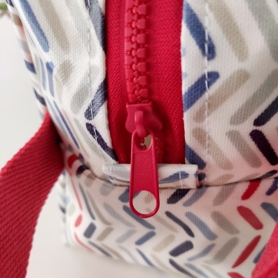 Bolsa colorida com fecho de correr e alças vermelhas