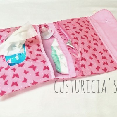 Estojo organizador cor-de-rosa com padrão de borboletas e divisórias com fraldas e lenços