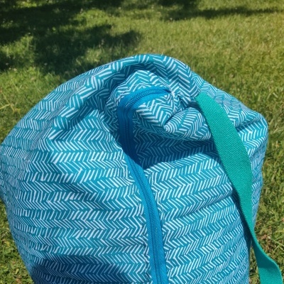 Mochila ou mala azul com padrão branco sobre relva