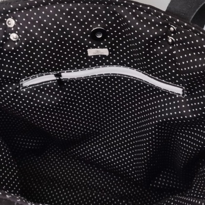 Interior de mala preta com bolinhas brancas e bolso de fecho branco