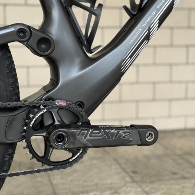 Detalle do quadro e pedaleira de uma bicicleta preta com texto INNOVATION TECHNOLOGY DESIGN