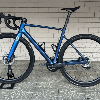 Bicicleta de estrada azul metálica com quadro em carbono e componentes pretos