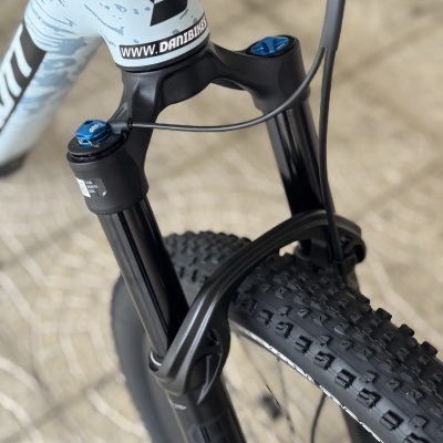 Garfo de suspensão de bicicleta preta com detalhes azuis e quadro azul com padrão cinza.