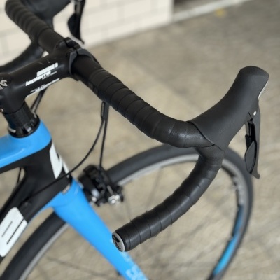 Guiador preto de bicicleta de estrada com componentes Shimano e quadro azul e preto