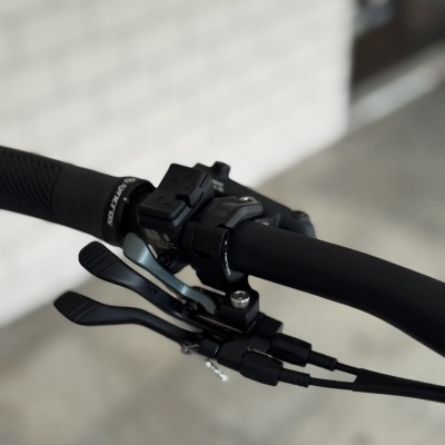 Punho e manete de bicicleta preta com alavancas de mudanças e cabos