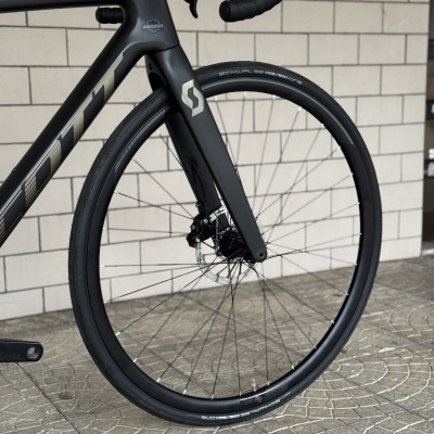 Roda dianteira de bicicleta de estrada preta com disco de travão e pneus Schwalbe.