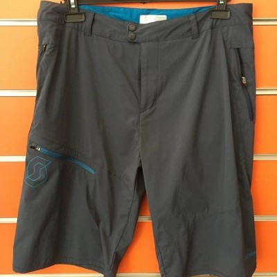 Calções técnicos cinzentos escuros com detalhes azuis pendurados num cabide