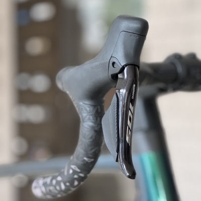 Punho e manete de travão de bicicleta com fita preta e padrão cinza e branco, manete preta Shimano 105