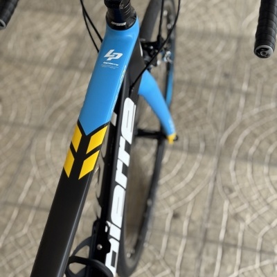 Quadro de bicicleta de estrada com cores azul, preto e amarelo e guiador preto