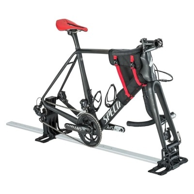 Bicicleta de estrada preta com selim vermelho num suporte metálico