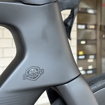 Quadro cinza fosco de bicicleta com autocolante DANIBIKES BIKE SHOP e pneu preto