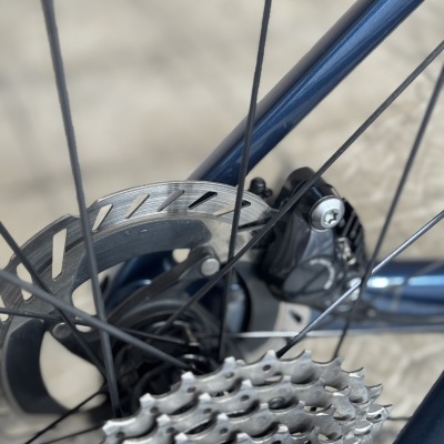 Roda traseira de bicicleta azul com disco de travão e pinhão em metal prateado