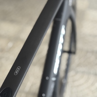 Bicicleta preta com texto addic eRIDE em fundo de pavimento em pedra clara