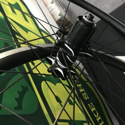 Roda de bicicleta preta com raios metálicos finos e cubo central preto