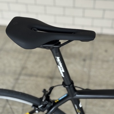 Selim de bicicleta preto TOFINO com corte central montado num quadro preto e amarelo