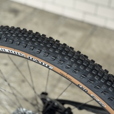 Pneu de bicicleta todo-o-terreno com cravos pretos e lateral castanha