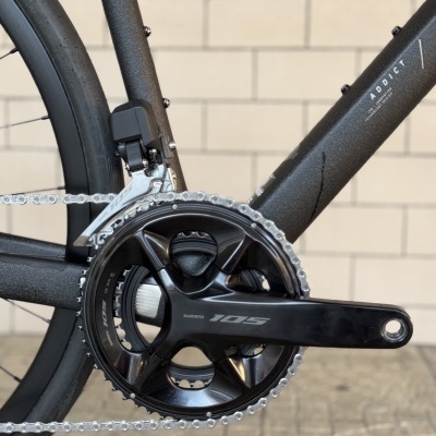 Pedaleira Shimano 105 preta em quadro de bicicleta cinza com decalque ADDICT