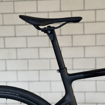 Assento e parte traseira de bicicleta preta com parede de azulejos ao fundo