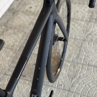 Bicicleta de estrada preta com quadro em carbono mate texturizado e texto ADDICT no quadro