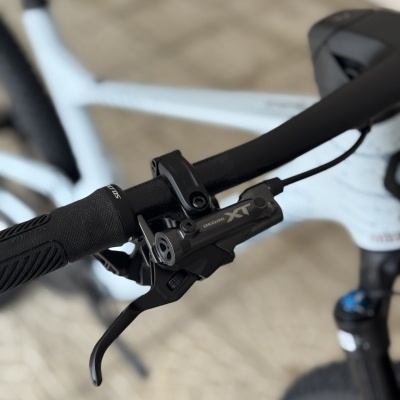 Guiador preto de bicicleta com manete de travão DEORE XT e punho antiderrapante.