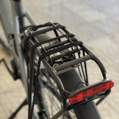 Suporte de bagagem traseiro preto com luz vermelha numa bicicleta