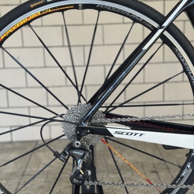 Roda traseira de bicicleta com pneu Continental GRANDPRIX, aro Mavic KSYRIUM SL, desviador Shimano Ultegra, em quadro SCOTT preto e branco.