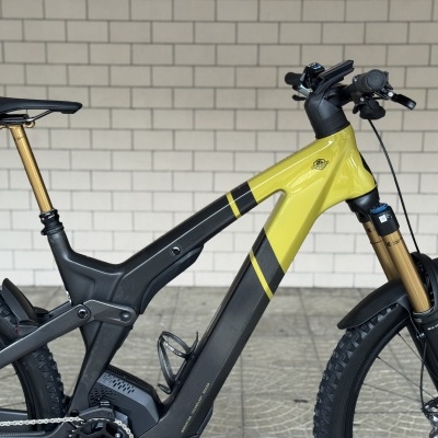 Bicicleta elétrica de montanha amarelo e preta com suspensão dourada e pneus Maxxis