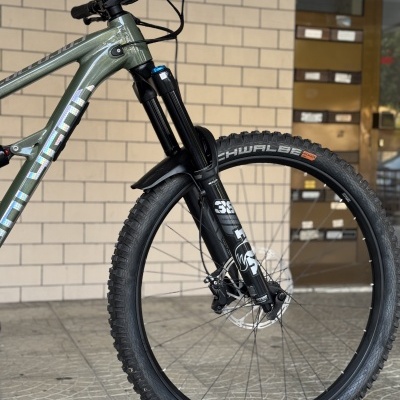 Bicicleta de montanha com quadro verde metálico e garfo preto FOX 38