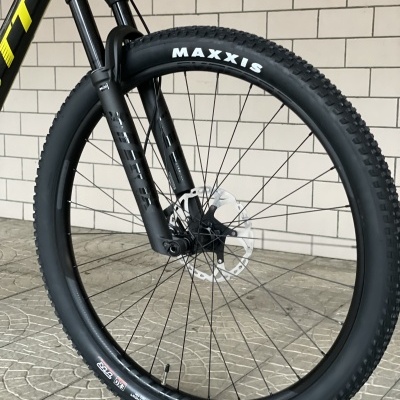 Roda dianteira de bicicleta com pneu Maxxis em preto e suspensão dianteira