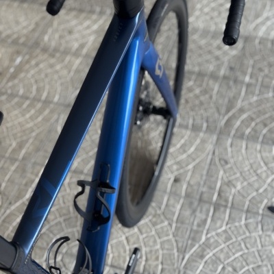 Bicicleta de estrada azul escuro com guiador preto e suporte para garrafa