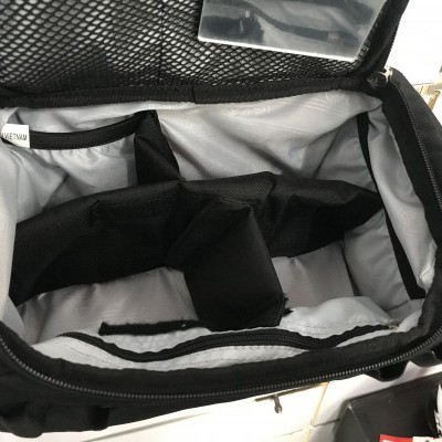 Bolsa preta com divisórias internas e fecho de correr aberta