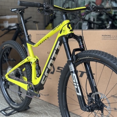 Bicicleta de montanha Scott amarela e preta com suspensão dianteira e traseira, pneus CrossKing e travão de disco dianteiro.