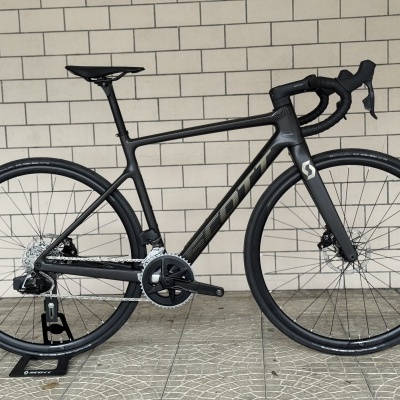 Bicicleta de estrada preta com marca SCOTT e pneus Schwalbe One