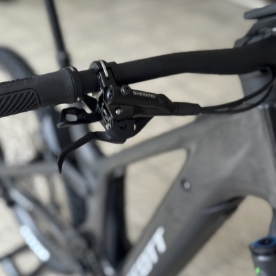 Bicicleta preta com guiador e travão SHIMANO close-up