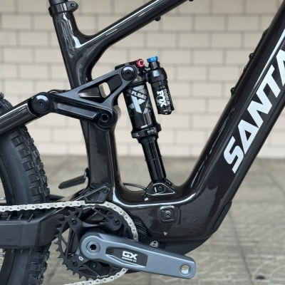 Detalhe da parte inferior de bicicleta elétrica preta SANTA CRUZ com suspensão traseira FOX e pedaleira GX SRAM.