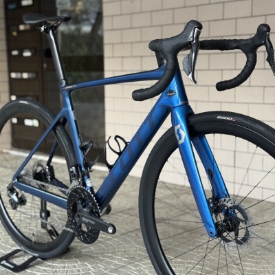 Bicicleta de corrida azul metálica SCOTT com pneus pretos e guiador em drop