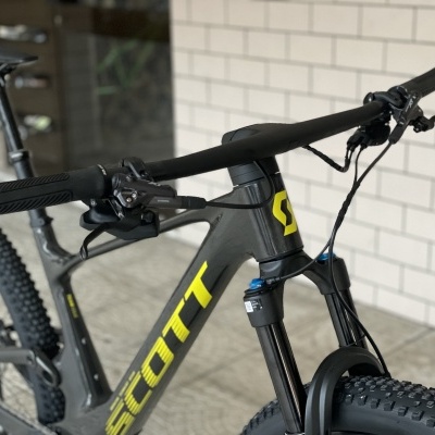 Bicicleta de montanha SCOTT preta com detalhes amarelos em garagem