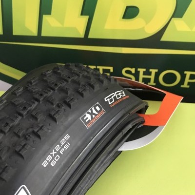 Pneu de bicicleta preto com relevo e texto branco sobre embalagem verde com letras amarelas