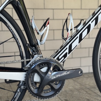 Bicicleta de estrada SCOTT com quadro preto e branco e pedalier Shimano ULTEGRA