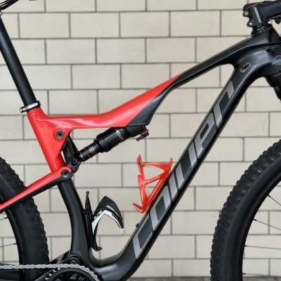 Quadro de bicicleta de montanha preto e vermelho com suspensão e porta-bidões.