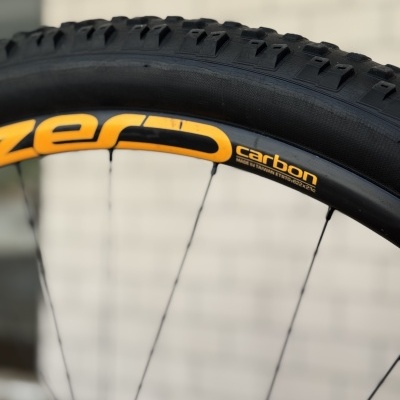 Pneu de bicicleta preto com texto amarelo zero carbon no aro