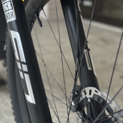 Roda dianteira de bicicleta com suspensão Rock Shox e pneu Maxxis preto e amarelo