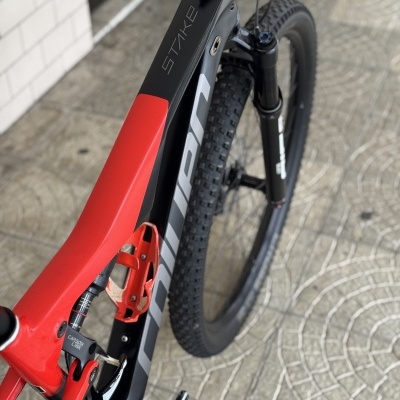 Bicicleta de montanha preta e vermelha com texto STAKE e CARBON LINK
